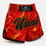 Red and gold fire marble Muay Thai boxing shorts with Wani logo, satin fabric, front view