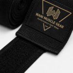 Close-up of Wani Muscle Gear logo patch on custom boxing hand wraps with velcro strap
