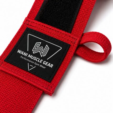Close-up of red Wani Muscle Gear hand wrap showing woven brand label, hook-and-loop closure, and thumb loop stitching