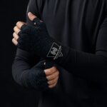 Boxer wrapping hands with Wani Muscle Gear custom hand wraps before training session