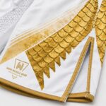 Gold dragon scale sublimation print close-up on custom MMA shorts leg panel Title: Golden Dragon MMA Shorts – Fabric Detail