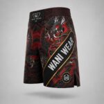 Side angled view of custom black and red dragon MMA fight shorts with Wani Wear branded waistband and side slit