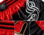 Custom red and black Muay Thai shorts front view with tribal embroidery design - Wani Wear